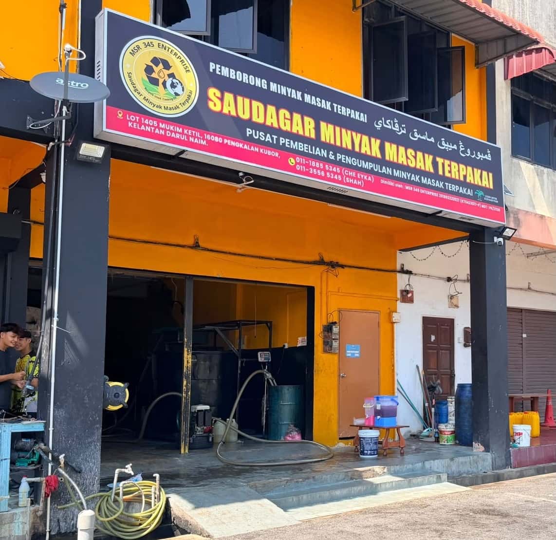 Golden oil flowing from a metal spout into a container