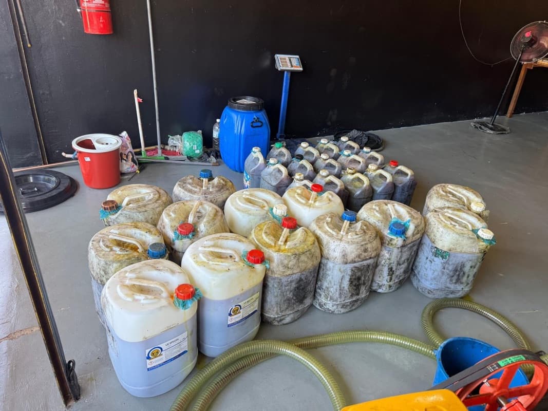 Large labelled jerry cans of used cooking oil received at the warehouse