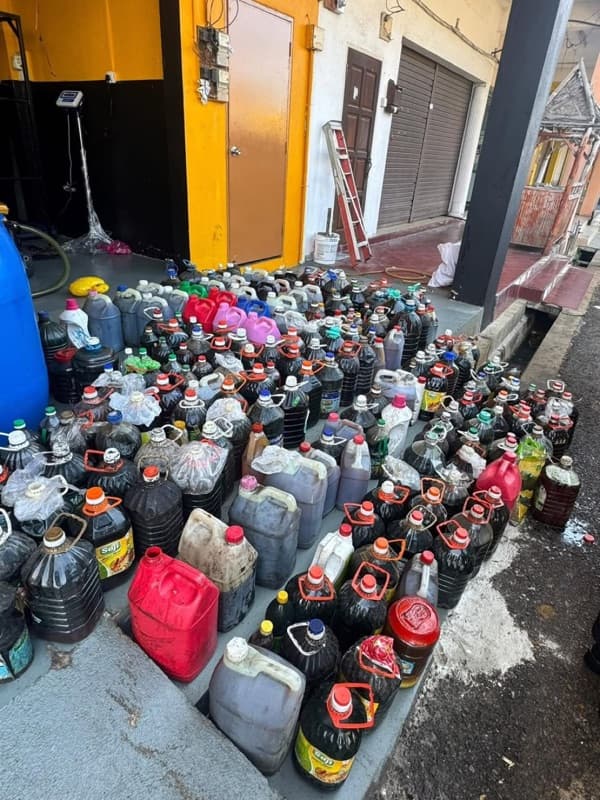 A customer bringing bottles of used cooking oil to the MSR warehouse