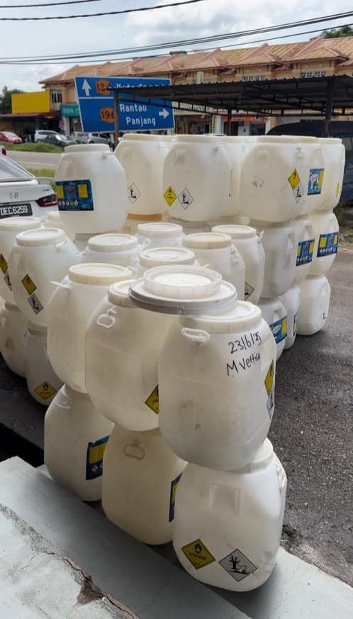 Large labelled white containers stacked up by the roadside