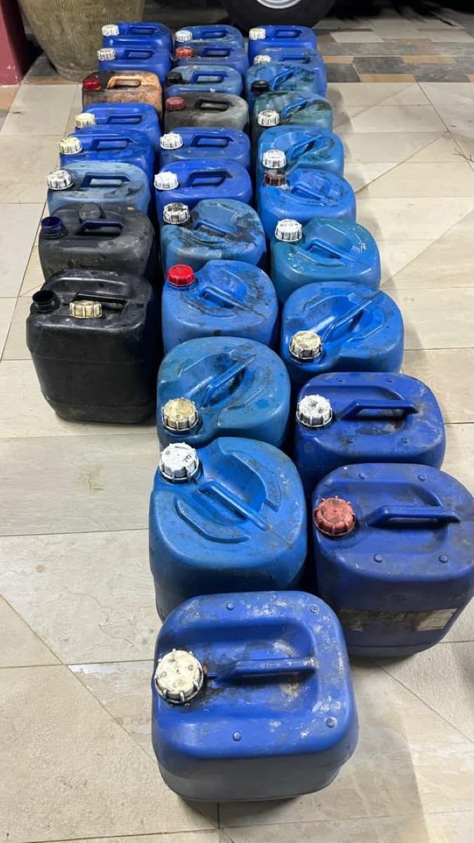 A row of blue and black plastic drums for storing used cooking oil